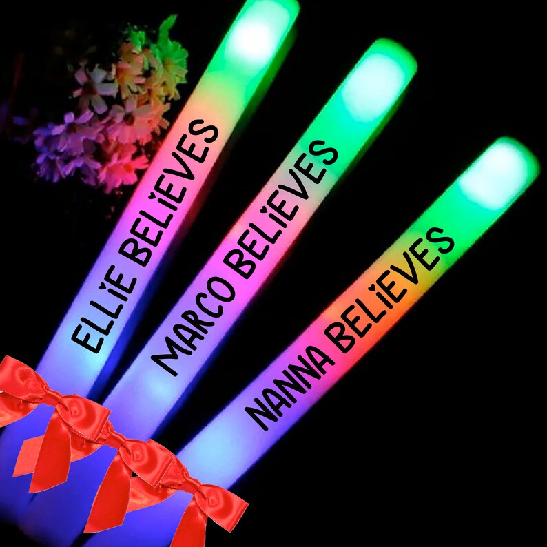 May include: Three rainbow glow sticks with the names "Ellie Believes", "Marco Believes", and "Nanna Believes" written on them.