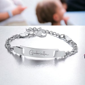May include: Silver chain bracelet with a personalized nameplate engraved with the name "Gabriella".