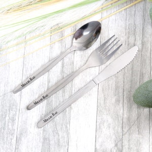Peut inclure: Un ensemble de trois couverts en argent gravés du nom "Millie Rae". Les couverts comprennent une fourchette, un couteau et une cuillère.