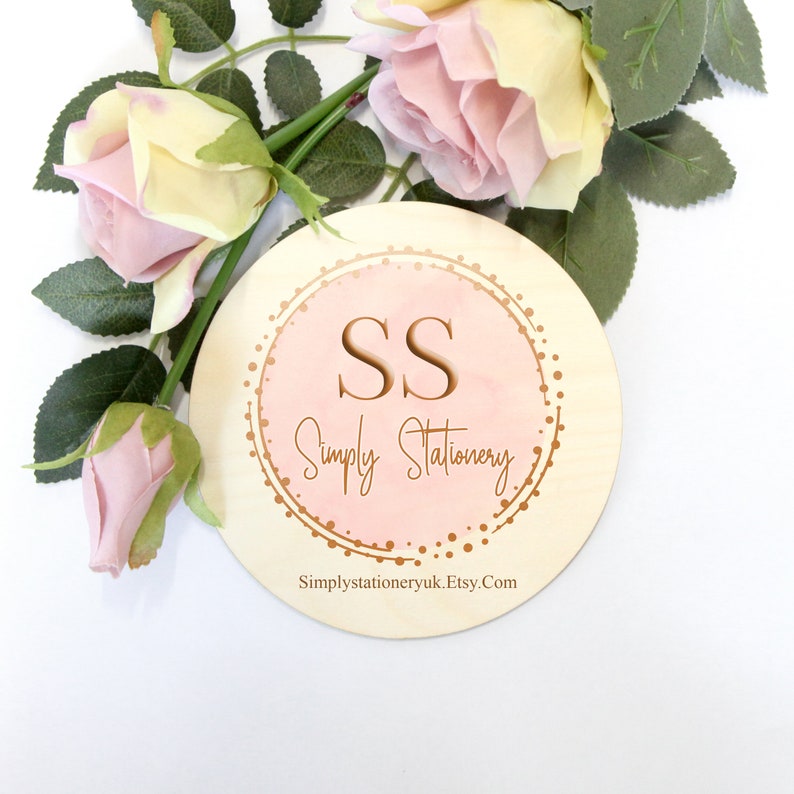 May include: A round wooden sign with a pink watercolor background and gold glitter. The sign says "SS Simply Stationery" and "Simplystationeryuk.Etsy.Com".