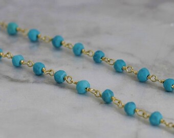 May include: A turquoise and gold beaded necklace with a delicate chain.