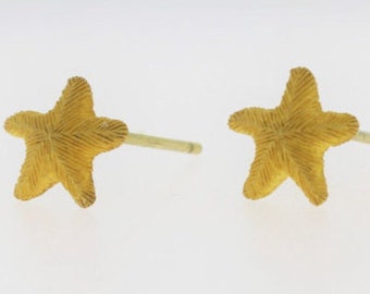 May include: A pair of gold starfish stud earrings. The earrings are small and delicate, with a textured surface.