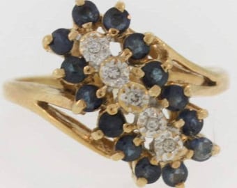 May include: A gold ring with a cluster of blue sapphires and white diamonds set in a floral design.