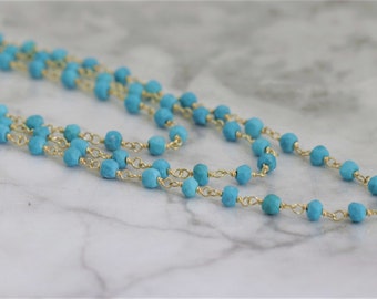 May include: A long turquoise and gold necklace with small, faceted turquoise beads and a delicate gold chain.