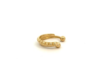May include: A gold ear cuff with a beaded design. The cuff is open and has a rounded end.