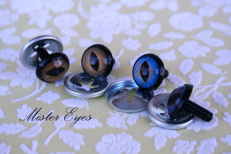 Puede incluir: Surtido de ojos de seguridad de pl&aacute;stico para manualidades, con iris marrones, azules y negros. Los ojos est&aacute;n unidos a arandelas de metal con un poste de pl&aacute;stico negro.