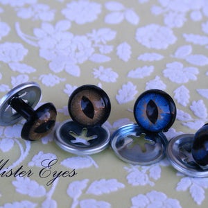 Puede incluir: Cinco juegos de ojos de seguridad de pl&aacute;stico para manualidades. Los ojos son negros con un iris marr&oacute;n o azul. Los ojos est&aacute;n unidos a arandelas de metal con un poste de pl&aacute;stico negro.