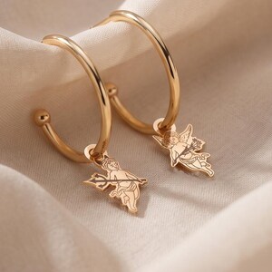 Pendientes de ángel y diablo · Aros con dije de querubín · Joyería asimétrica personalizada
