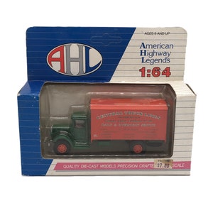 May include: A die-cast model of a green and red Central Truck Lines truck, packaged in a box. The box features the American Highway Legends logo and text. The truck is a 1:64 scale model.