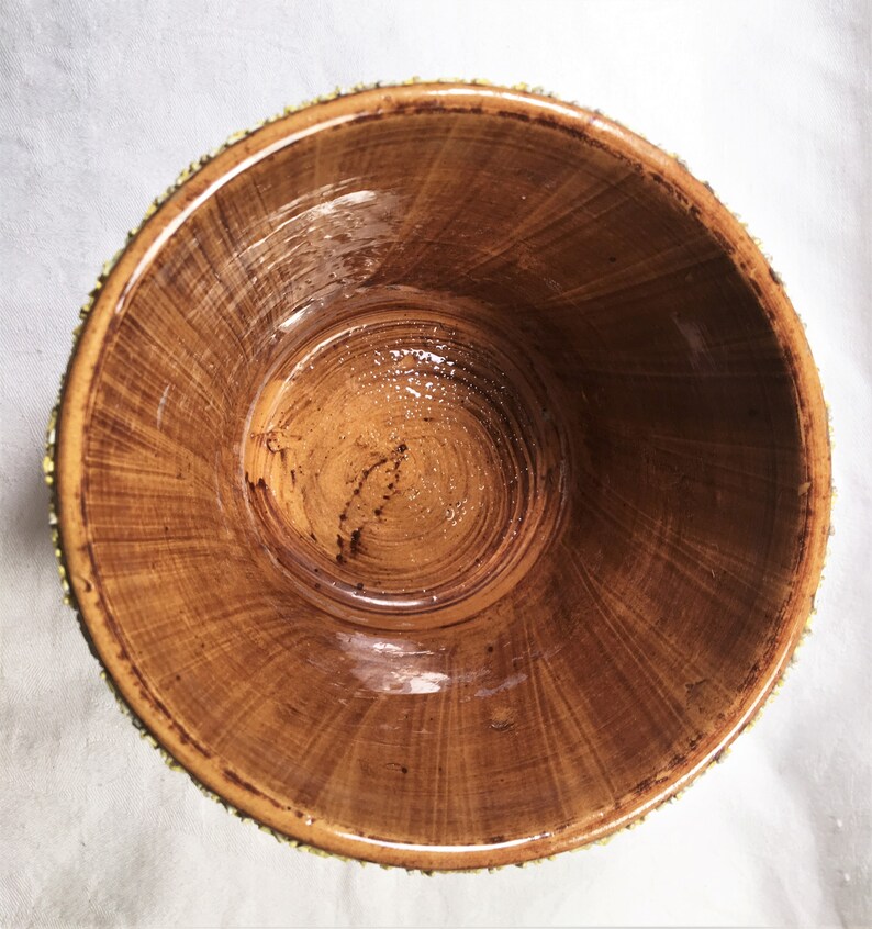 Puede incluir: Un cuenco de madera hecho a mano con un acabado marr&oacute;n c&aacute;lido natural. El interior muestra un patr&oacute;n de vetas en espiral, y el borde est&aacute; adornado con un ribete dorado decorativo. El dise&ntilde;o del cuenco sugiere que podr&iacute;a usarse para servir o exhibir.