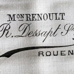 Puede incluir: Una etiqueta de tela blanca con texto negro que dice "Mon Renoult R. Dessapt Jeur Rouen".