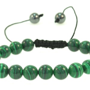 May include: A green malachite beaded bracelet with black cord and silver toggle closures.