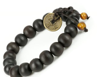 May include: A black wooden beaded bracelet with a gold coin charm and tiger eye beads. The coin has Chinese characters on it.