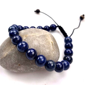 May include: A dark blue lapis lazuli beaded bracelet with a black cord adjustable closure.