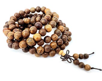 May include: A wooden bead bracelet with a tassel. The beads are round and have a striped pattern in shades of brown and tan. The tassel is made of smaller beads and a knotted cord.