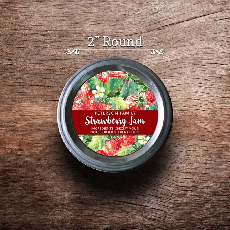 May include: A 2-inch round jar lid label with a watercolor illustration of strawberries and leaves. The label is red and white with the text "PETERSON FAMILY Strawberry Jam" and "INGREDIENTS: SPECIFY YOUR NOTES OR INGREDIENTS HERE".
