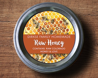 May include: A silver jar lid with a label that reads "Dirkse Family Homemade Raw Honey Contains: Raw Colorado Honey & Love". The label is surrounded by a watercolor illustration of a honeycomb with bees.