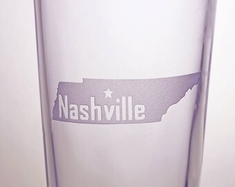 May include: A clear glass pint glass with an etched design of the state of Tennessee and the word "Nashville" with a star above it.