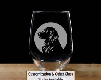 May include: A clear glass wine glass with a black silhouette of a dog's head in a circle on the front. The text "Customization & Other Glass Styles Available" is below the glass.
