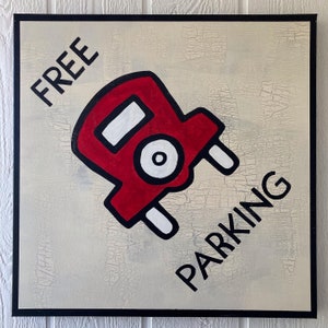 May include: A white sign with black text that says "FREE PARKING" and a red cartoon car with white wheels and a black outline.