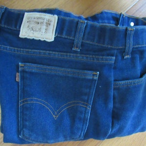 May include: A pair of blue denim jeans with a brown leather patch that says "Levi Strauss & Co. San Francisco, Cal."
