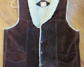 May include: A brown suede vest with a white faux fur collar and lining. The vest has a snap closure and two pockets. The label on the vest reads "L.B.  Leather Co."