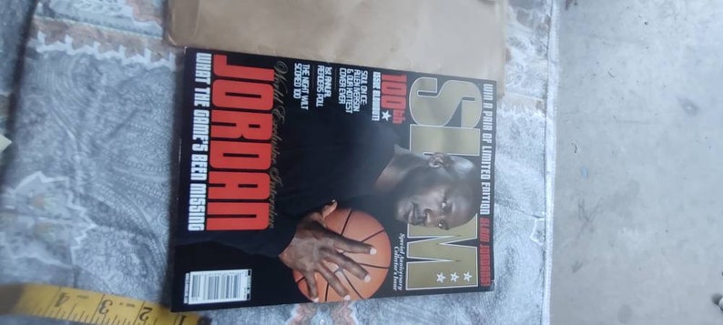 May include: A magazine cover featuring Michael Jordan holding a basketball. The cover has the text "JORDAN" in large red letters, with the headline "WHAT THE GAME'S BEEN MISSING." The magazine is a limited edition.
