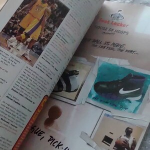 May include: An open magazine with the title "TRASH TALK" visible. The pages feature basketball-related content, including images of players in action and advertisements for athletic footwear. The phrase "SUE, PICK-UP GAMES..." is written on the page.