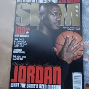 May include: A magazine cover featuring Michael Jordan holding a basketball. The magazine title is "SLAM" in large gold letters. The cover includes text that reads "100th Issue Blowout!" and "JORDAN".