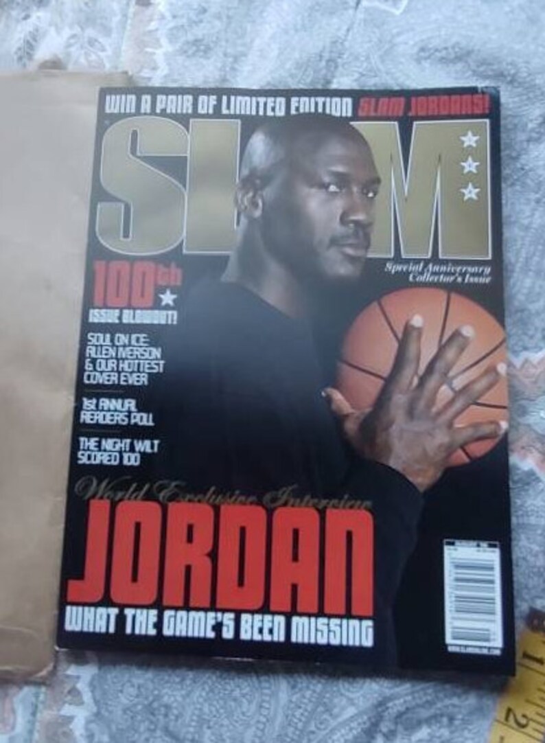 May include: A magazine cover featuring Michael Jordan holding a basketball. The magazine title is "SLAM" in large gold letters. The cover includes text that reads "100th Issue Blowout!" and "JORDAN".