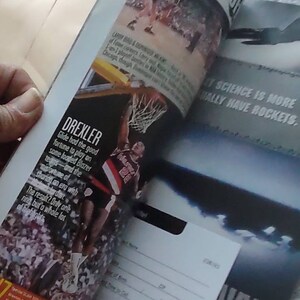 May include: Magazine pages featuring basketball action shots and text. One page highlights Clyde Drexler in a Portland Trail Blazers uniform. Another page has the text "THE TIP OFF". A Navy recruitment ad is also visible.