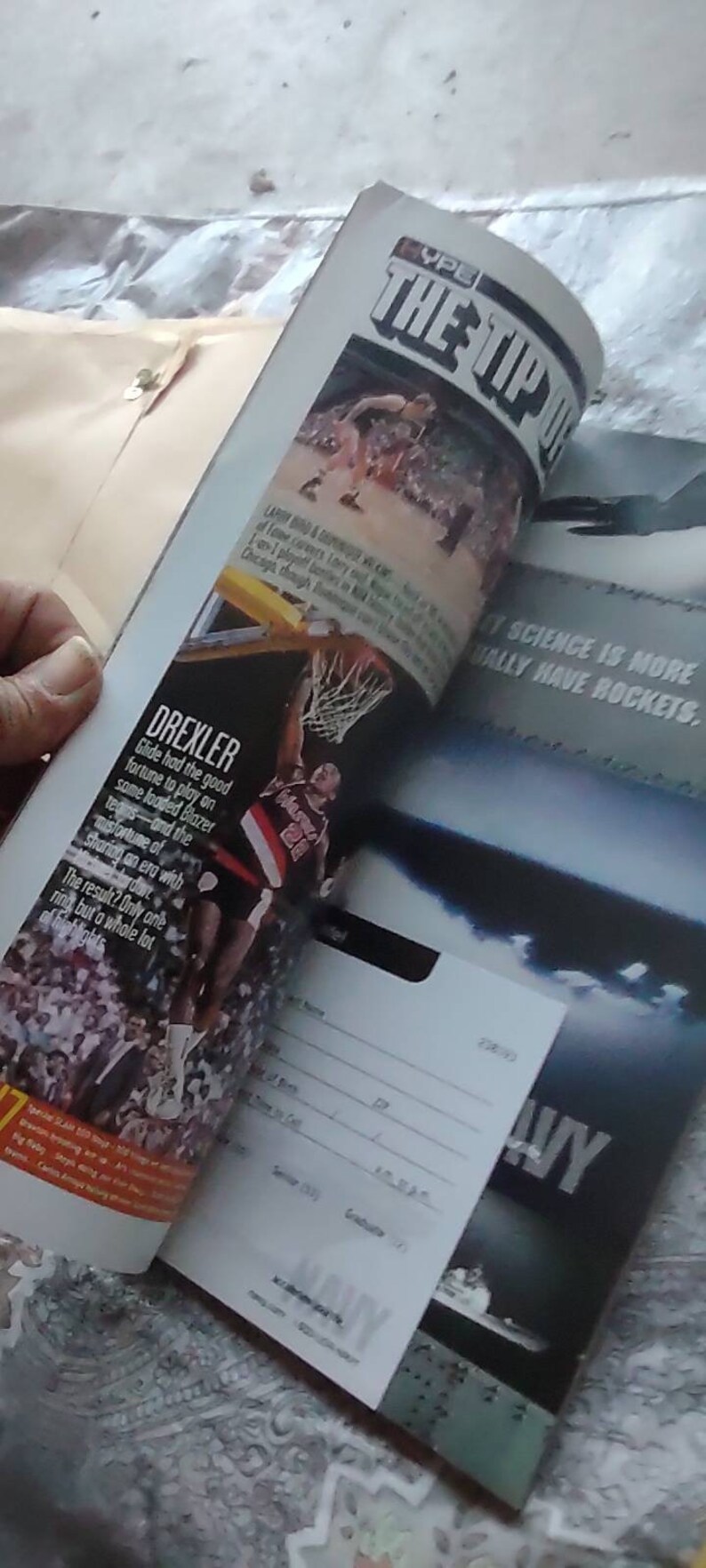 May include: Magazine pages featuring basketball action shots and text. One page highlights Clyde Drexler in a Portland Trail Blazers uniform. Another page has the text "THE TIP OFF". A Navy recruitment ad is also visible.