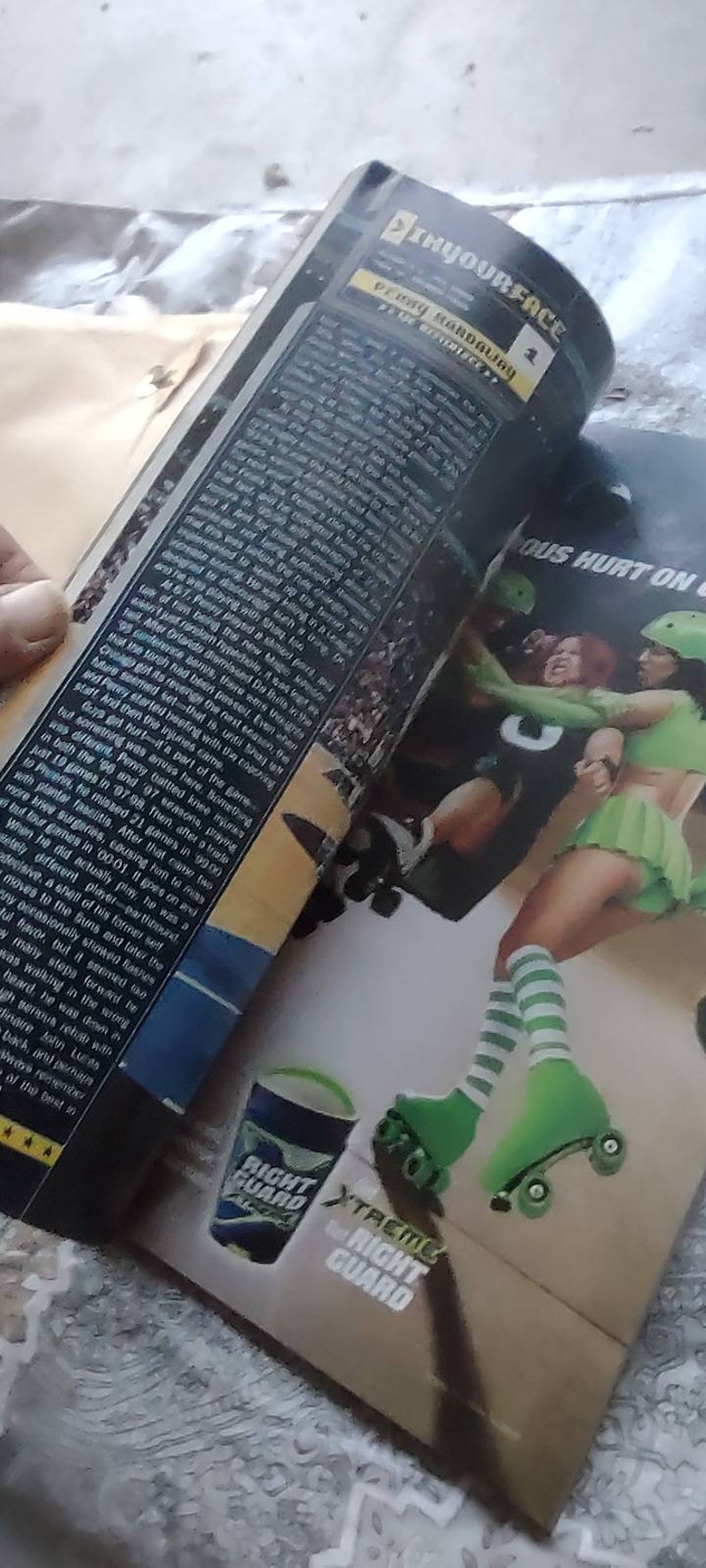 May include: An open magazine with a roller derby theme. The pages show action shots of roller derby athletes in green and white uniforms, roller skates, and a Right Guard product. Text includes "INYOURFACE" and "Xtreme Right Guard."