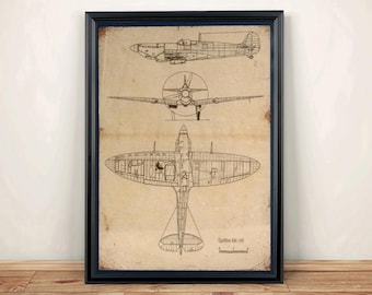 May include: A framed print featuring a technical blueprint of a Spitfire Mk. VB aircraft. The illustration displays the plane from side, front, and top perspectives in black ink on a tan, aged-looking paper background with dark corner accents.