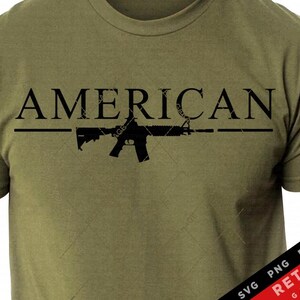 May include: A green t-shirt with the word "AMERICAN" printed in black letters above a silhouette of a rifle.