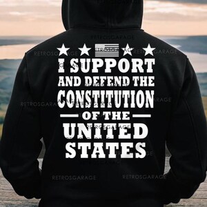 May include: Black hooded sweatshirt with white text that reads "I support and defend the Constitution of the United States". The text is surrounded by four stars and a small American flag.