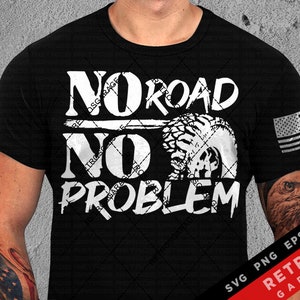 Puede incluir: Camiseta negra con texto blanco que dice "No Road No Problem" con un gráfico de banda de rodadura de neumático. La camiseta también tiene un pequeño gráfico de bandera estadounidense en la manga derecha.