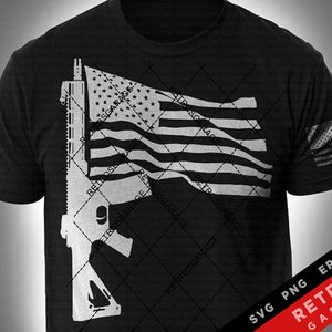 May include: A black t-shirt with a white silhouette of an AR-15 rifle and an American flag waving behind it. The text "RETROS GARAGE" is repeated in a diagonal pattern across the image.