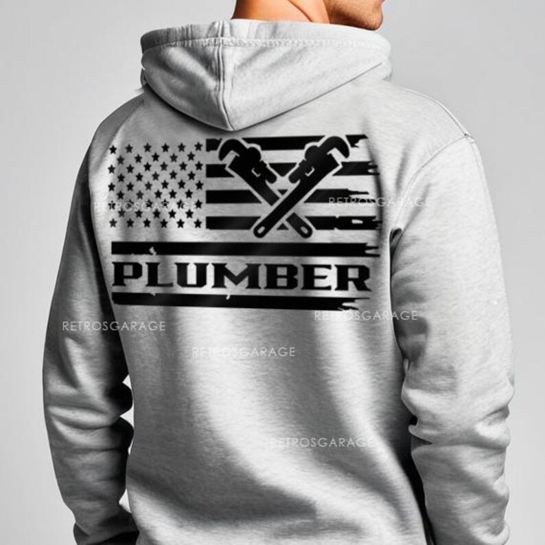 May include: A gray hooded sweatshirt with a black and white American flag design featuring two crossed wrenches and the word "PLUMBER" underneath.