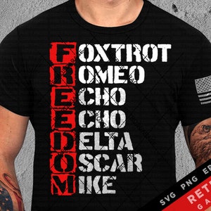 May include: Black t-shirt with white text spelling out "FREEDOM" using the phonetic alphabet. The letters are stacked vertically and the text is in a distressed font. The shirt also features a small American flag on the right sleeve.