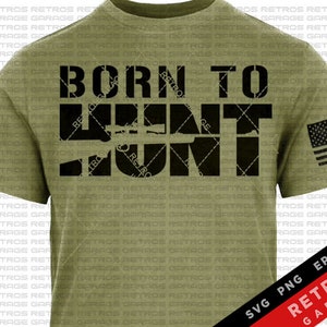 May include: A green t-shirt with the text "Born to Hunt" in black letters. The text is overlaid with a silhouette of a rifle. A small American flag is in the lower right corner of the shirt.