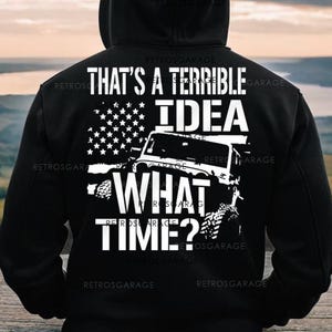 May include: Black hooded sweatshirt with a white graphic print of a jeep with an American flag and the text "That's a terrible idea what time?"