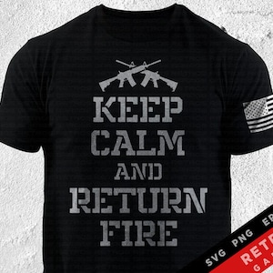 May include: Black t-shirt with the phrase "KEEP CALM AND RETURN FIRE" in distressed gray lettering. Two crossed rifles are above the text. An American flag is printed on the right sleeve. The shirt is a classic crew neck.