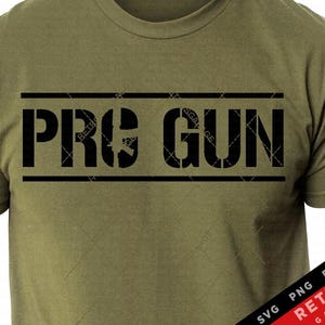 May include: A green t-shirt with the text "PRO GUN" in black letters on the front. The text is in a bold, blocky font and is surrounded by a black border.