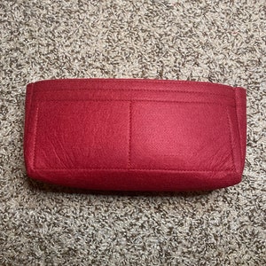 May include: A red felt bag insert with two large pockets and a stitched border.