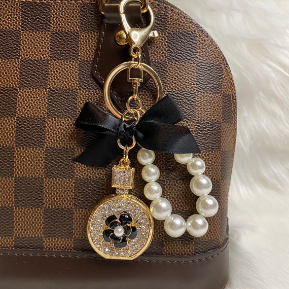 PERFUME & PEARL BAG CHARM W/BLACK BOW PERFUME & PEARL BAG CHARM W/BLACK BOW