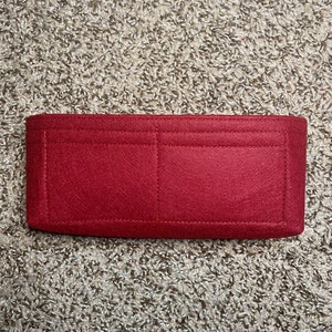 May include: Red felt bag insert with multiple compartments and stitching details.
