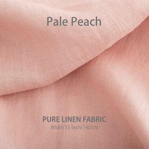 Delicate pale peach pure organic linen fabric, gently folded and available by the yard, showcasing premium European quality.