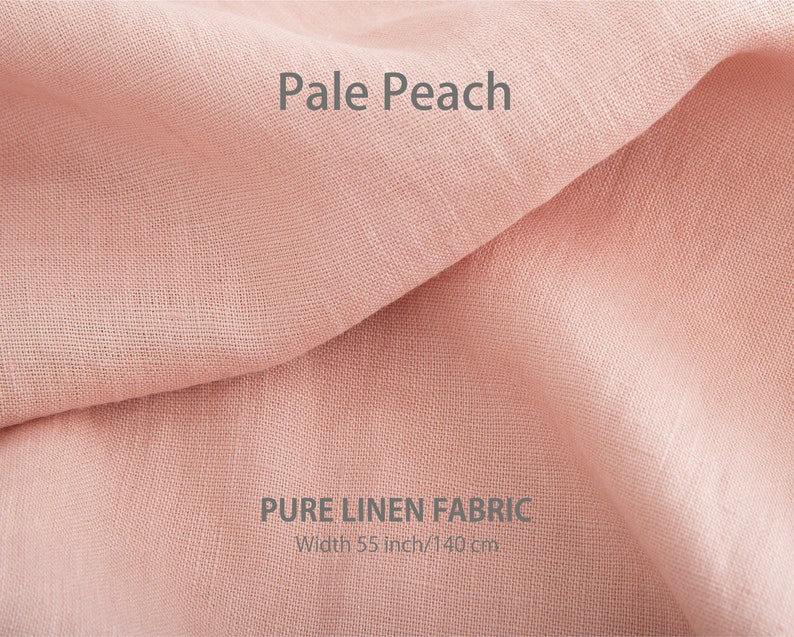 Delicate pale peach pure organic linen fabric, gently folded and available by the yard, showcasing premium European quality.