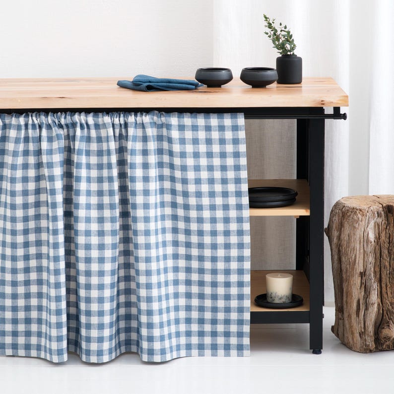 Blue gingham cafe panels decorate a cottage pantry window. Short length and soft cotton fabric offer cozy charm and vintage feel.